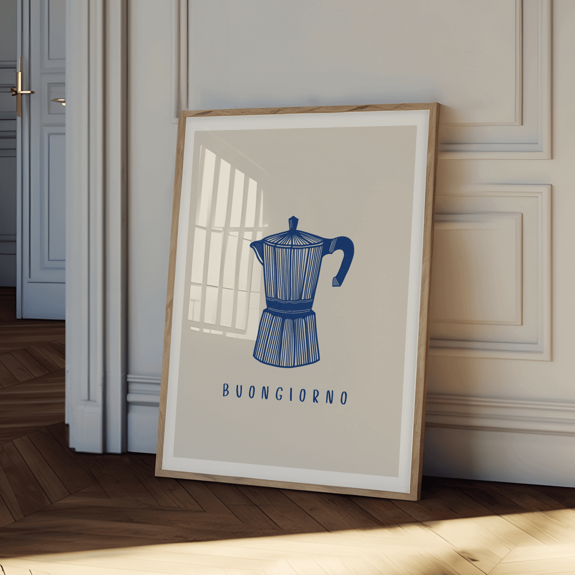 An illustration of an italian coffee moka pot, in navy against a neutral cream-beige background with the typography "buongiorno", print is framed leaning against a wall. Simplistic, stylish design