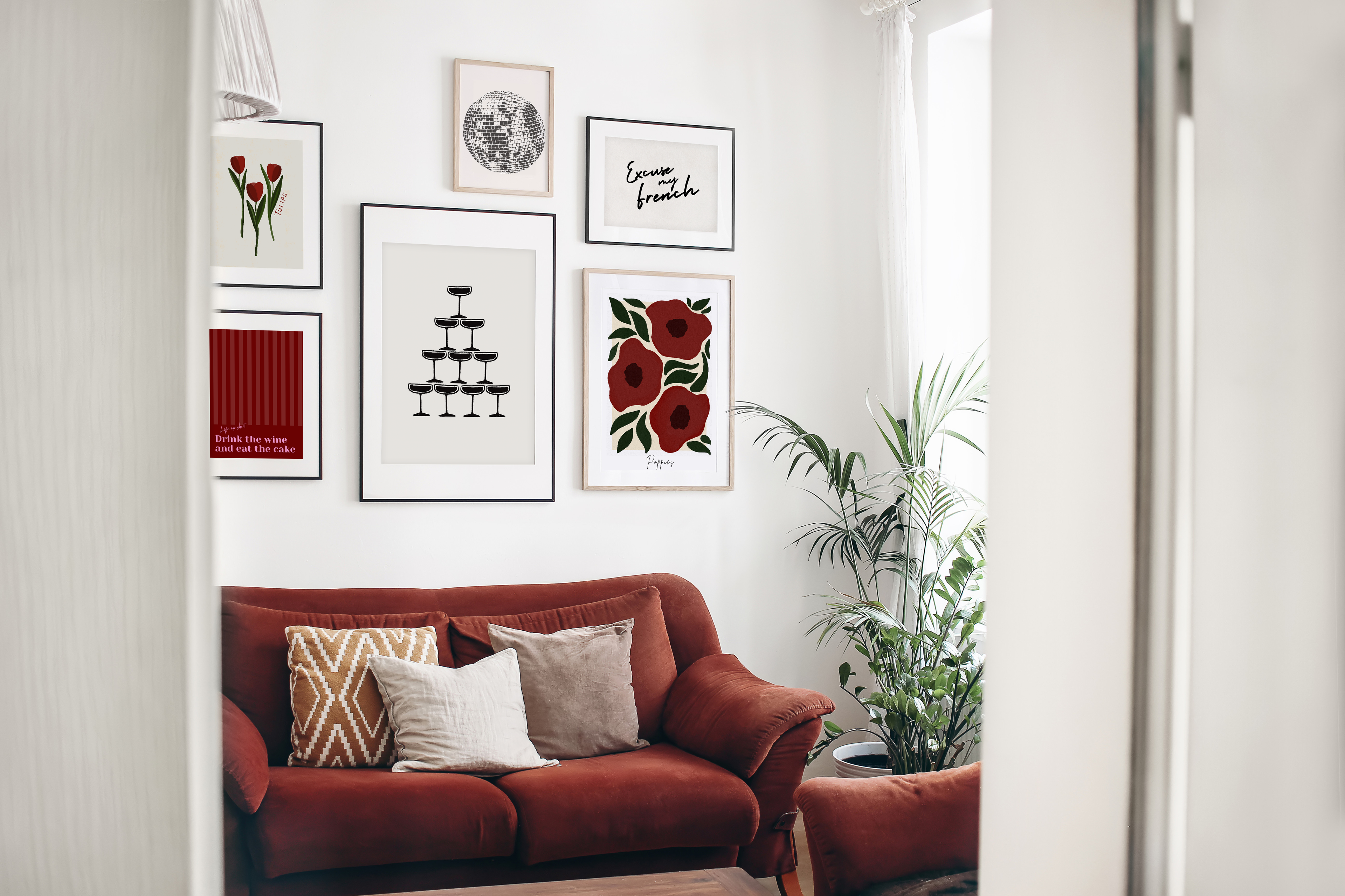 A selection of art prints presented on a gallery wall in a living room setting.