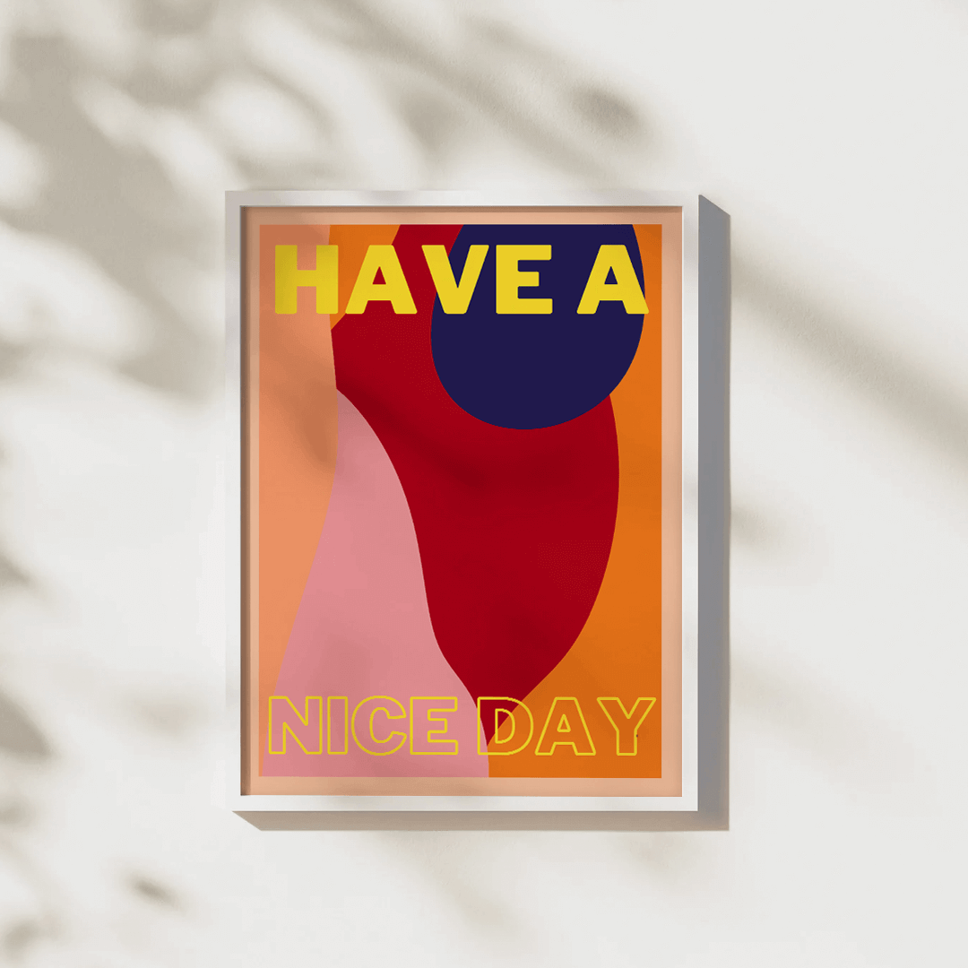 Print features block typography saying "Have a nice day". The background features abstract shapes and a variety of complimentary red, navy, peach and orange shades. The typography is yellow for a statement look. Displayed in a white frame on a wall with t