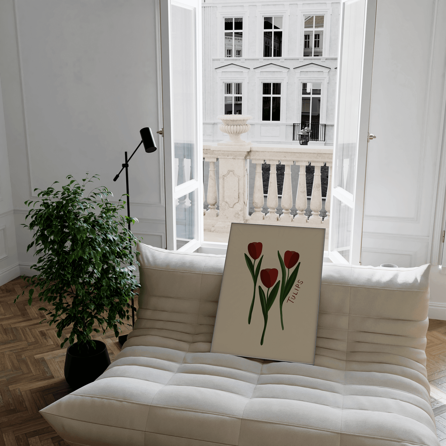 Simplistic print of three red tulips, with green stems against a beige background. Displayed in a frame leaning in a Parisian room on a modern minimalistic sofa.